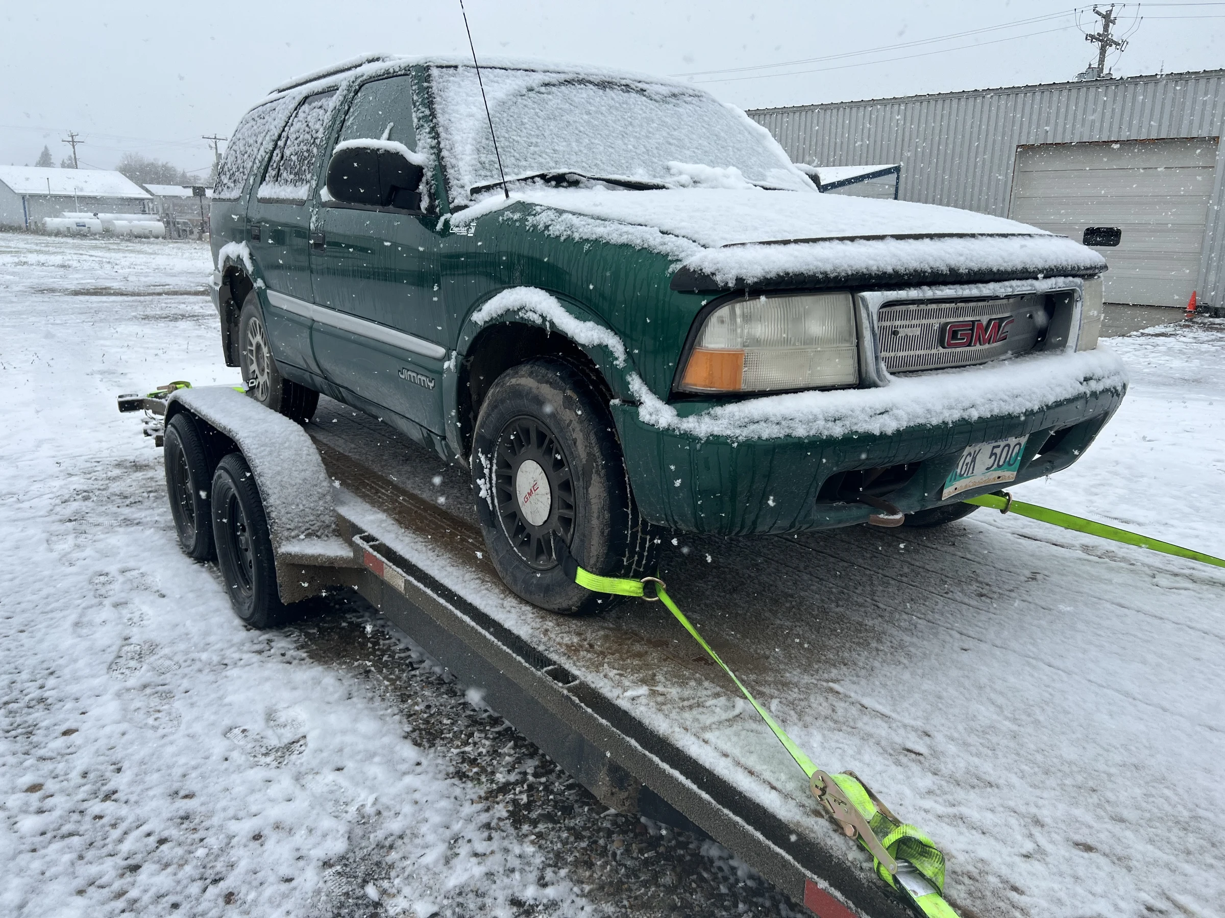 Snow-covered GMC SUV on trailer