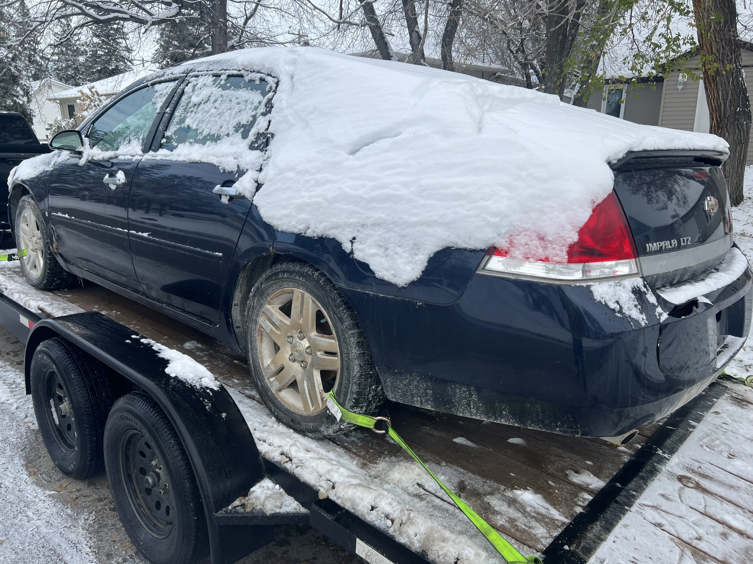 Snowy blue sedan on trailer